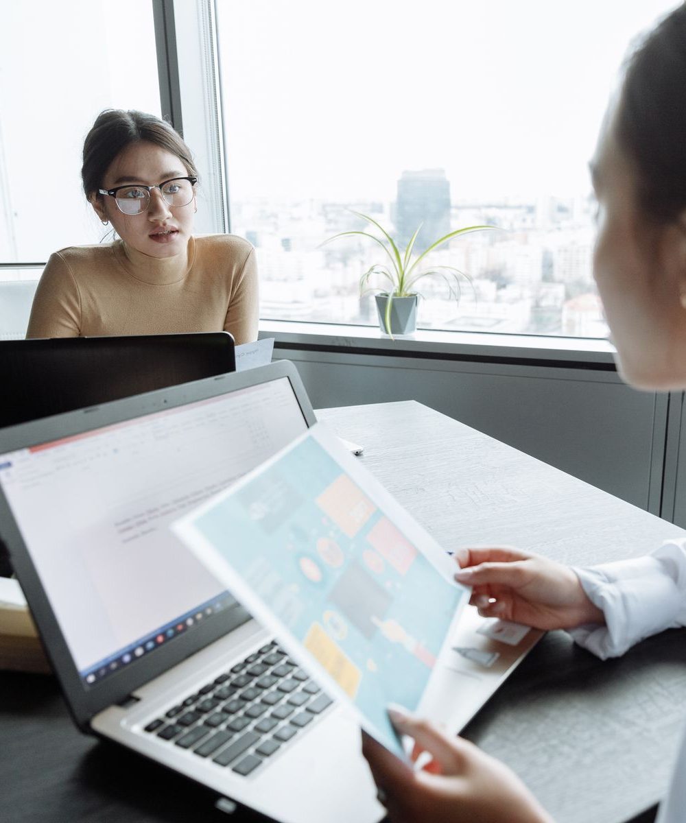 Two advisers meeting at the office with a city view